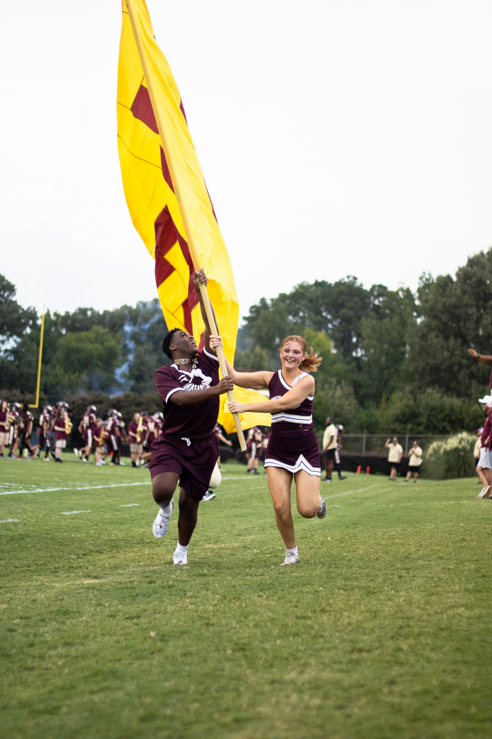 Wildcat Cheerleaders run the flag across the field after a Ninety Six touchdown